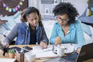 Two young women looking at financial information.