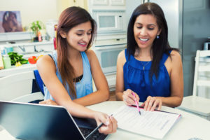 Mother and teenage daughter filling out college applications.