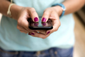 Girl holding smart phone outside