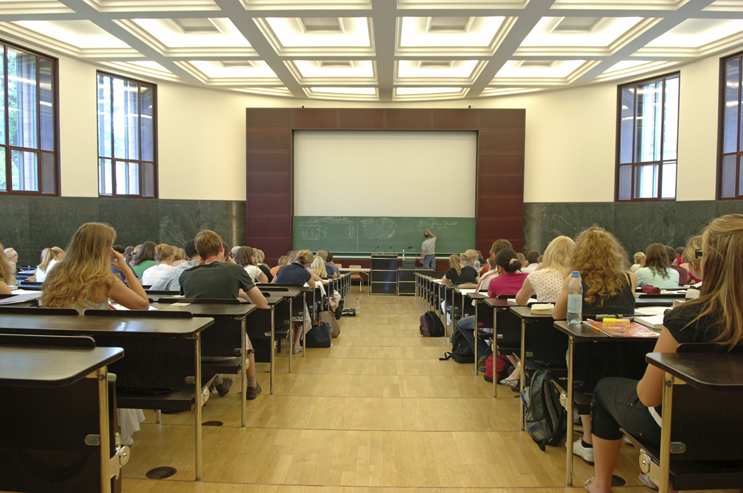 Large classroom with a chalk board at the very front.