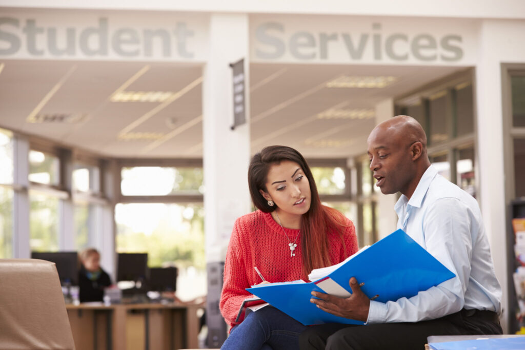 A student talking to a faculty member in Student Services.