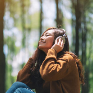 a student in a park listen to music