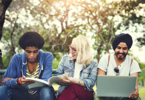 three students sitting on a bench.