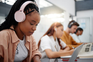 Black student studying while she is listening to music.