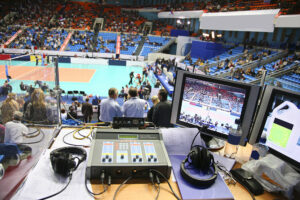 the view of a volleyball court from the commentator box. It shows the technology used to view the court and how it is filmed for a television audience.
