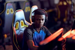 professional gamer wearing headphones looking at camera and smiling while participating in eSport tournament